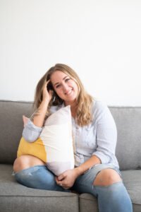 Woman sitting on a couch and smiling in her Ottawa lifestyle branding photo shoot