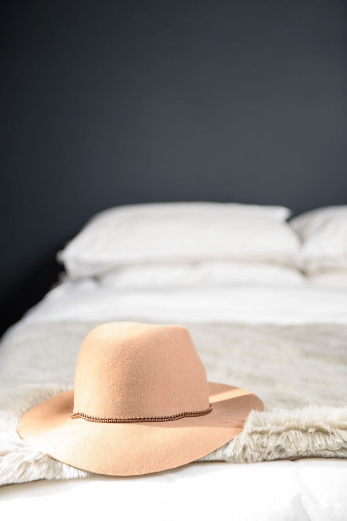 camel hat laying on white bed